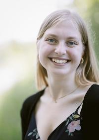 Brandi Klee, smiling, wearing a black top with flowers on it