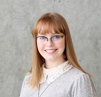 Heather Wiebe smiling wearing glasses and a grey sweater 